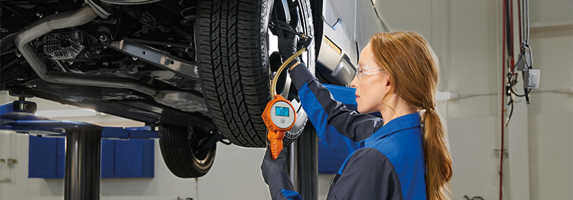 A Subaru technician checking tire pressure. | Bergstrom Subaru Oshkosh in Oshkosh WI