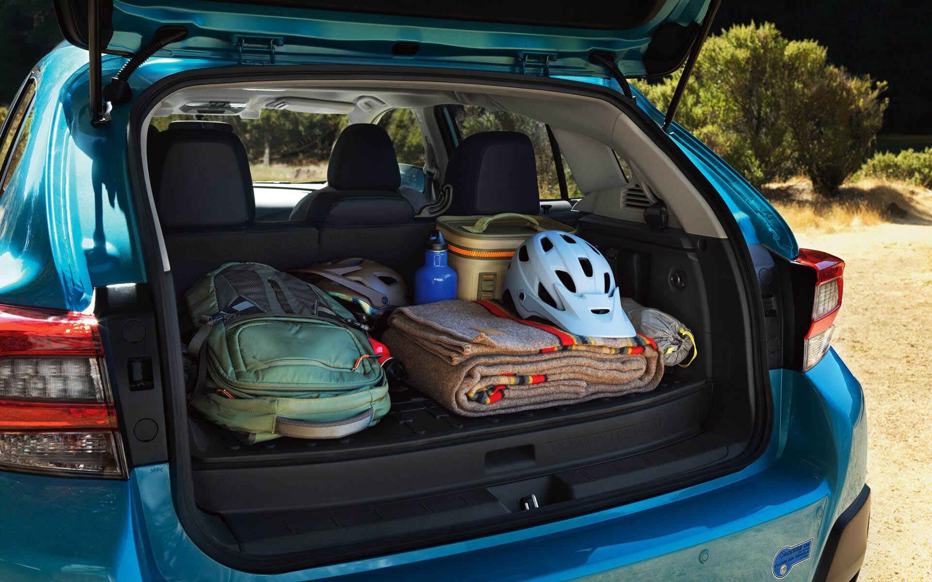 A backpack, blanket, and bike helmet in the rear cargo area of a Crosstrek Hybrid | Bergstrom Subaru Oshkosh in Oshkosh WI