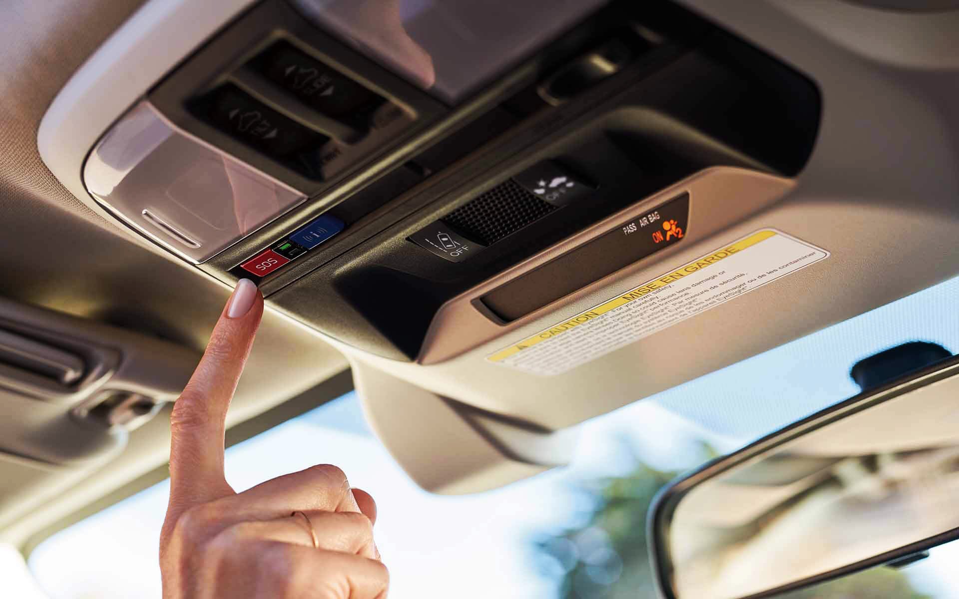 A finger pressing the Crosstrek Hybrid's SOS emergency assistance button | Bergstrom Subaru Oshkosh in Oshkosh WI